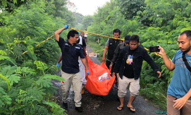 Petugas kepoliisian saat mengevakuasi jasad pria tanpa identitas di jalan inspeksi Kampung dan Desa Bendung, Kecamatan Tanara, Kabupaten Serang pada Senin, 25 Maret 2024. (Dok: Satreskrim Polres Serang)