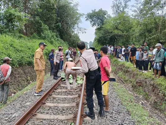 Personel Polsek Cikeusal bersama petugas Inafis melakukan olah TKP sebelum mengevakuasi jasad korban tertabrak kereta ke RS Bhayangkara. (Dok. Polsek Cikeusal)