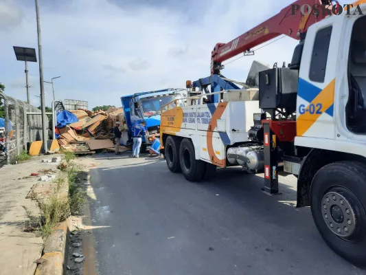 Proses evakuasi kendaraan truk di jembatan menuju akses Tol Balaraja Timur (Baltim), Kampung Kawidaran, Desa Cibadak, Kecamatan Cikupa, Kabupaten Tangerang pada Senin, 25 November 2024. (Poskota/Veronica Prasetio)