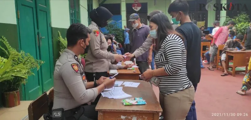 Ratusan warga yang terjaring razia vaksin didata dan divaksin di posko prokes di SD Pengadilan 1 Kota Bogor, tak jauh dari lokasi Pasar Anyar. (billy adhiyaksa)