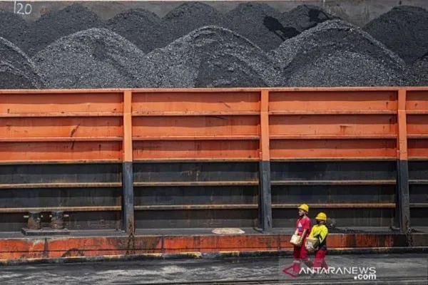 Ilustrasi: Pekerja melintas di dekat kapal tongkang pengangkut batubara di kawasan Dermaga Batu bara Kertapati milik PT Bukit Asam Tbk di Palembang, Sumatera Selatan. (Foto: Antara).