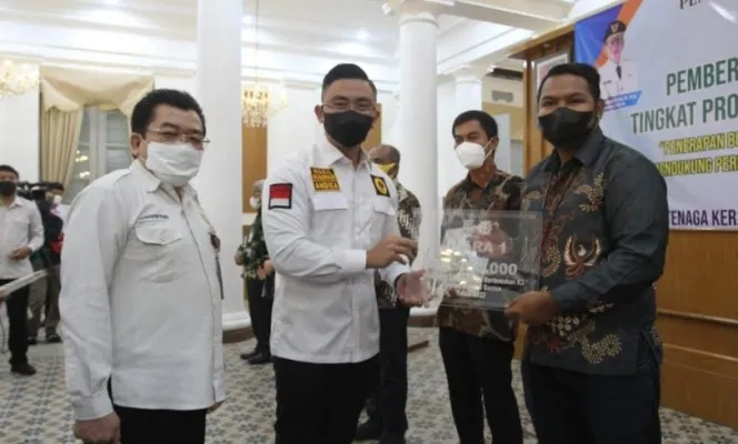 Wakil Gubernur Banten Andika Hazrumy didampingi Kadisnaker Alhamidi saat memberikan penghargaan. (ist)