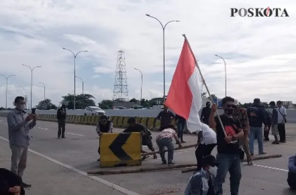 Aksi warga Jatikarya melakukan blokade di ruas jalan tol Cimanggis Cibitung. (Ihsan Fahmi).