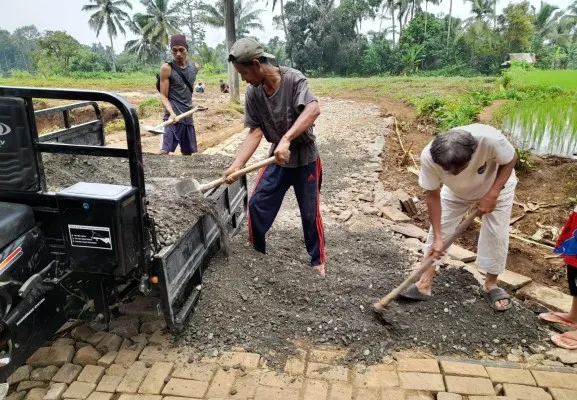 Sejumlah warga membangun jalan alternatif di Pandeglang, karena jalan utama rusak diterjang longsor. (Poskota.co.id/Samsul Fathony)