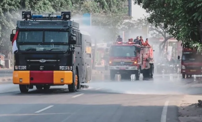 Mobil water canon saat melakukan penyemprotan jalan. (Foto/ist)