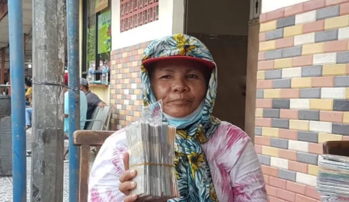 Junita, salah satu orang yang menerima jasa penukaran uang di terminal Kalideres. (Ist).